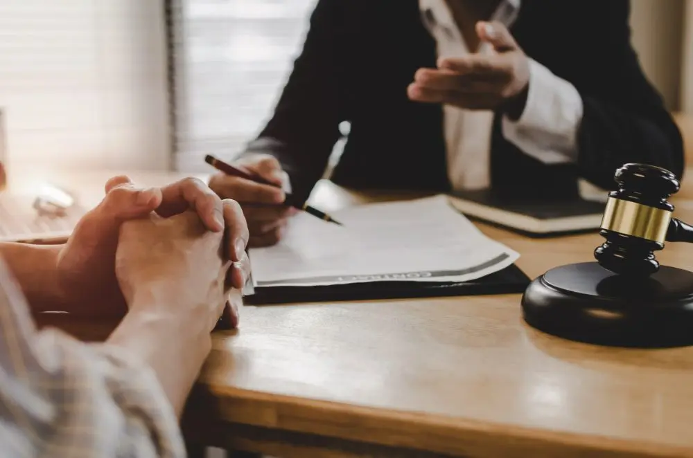 Business professionals discussing legal documents with gavel on wooden desk