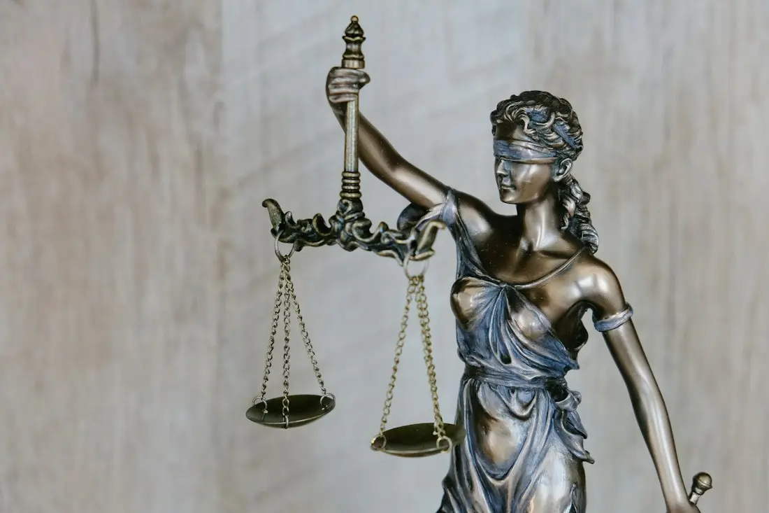 Bronze statue of Lady Justice holding scales and sword with blindfold